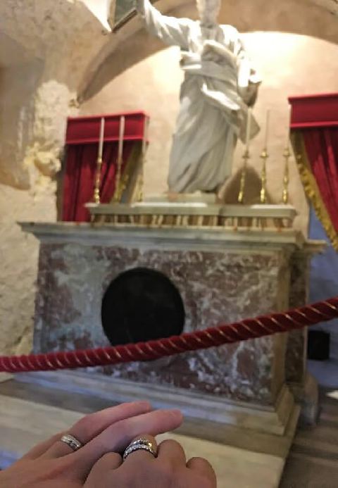 Married couple praying in front of St. Paul’s statue.