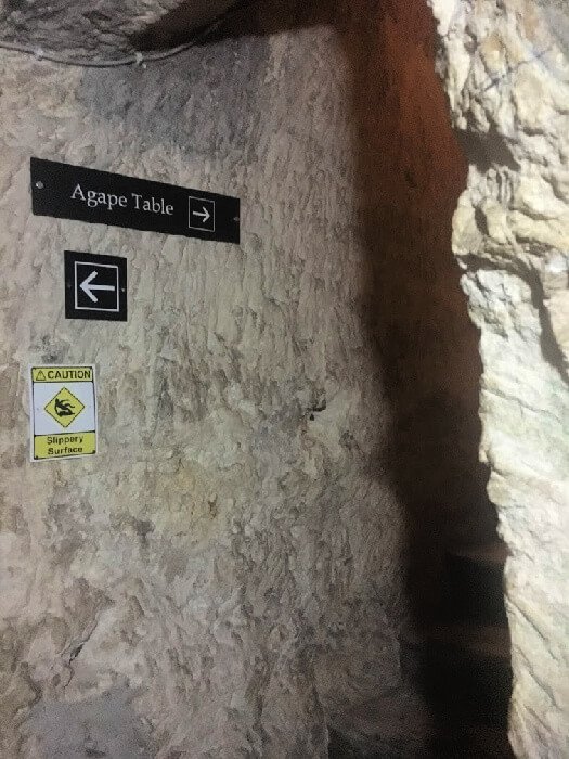 A sign pointing the way to the Agape Table in the catacombs of the The Agape Table inside the catacombs of the Wignacourt Museum.